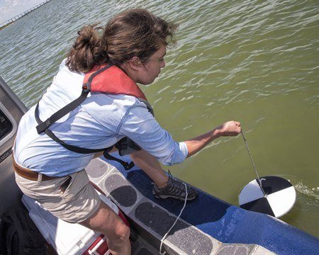 Mya Morales, Texas A&M student, tests water in the bay.