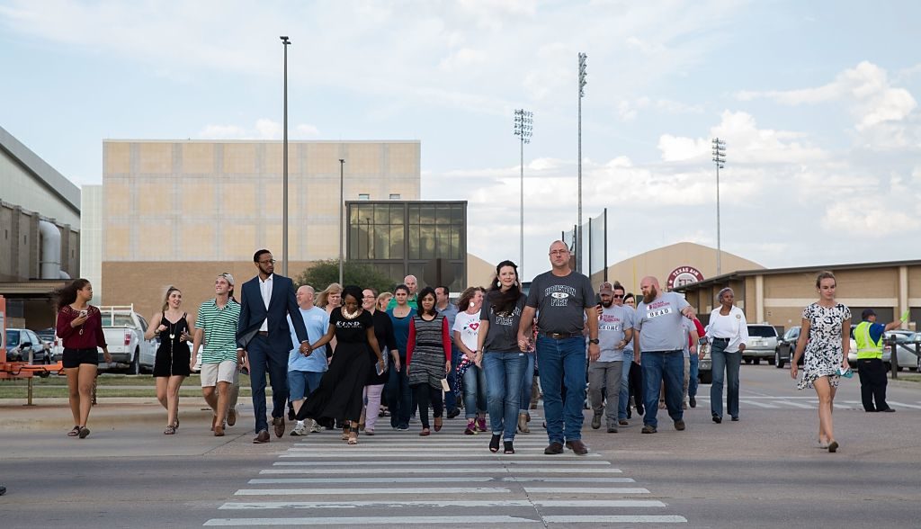 Group of Aggies walking across a crosswalk on campus