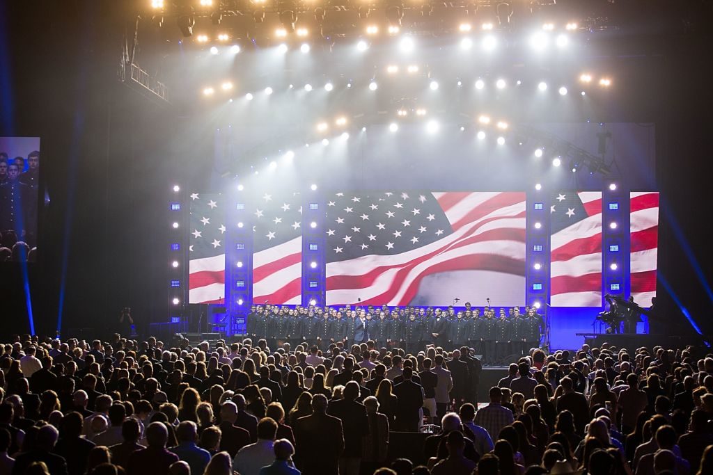 Lee Greenwood performs onstage with the Texas A&amp;M Singing Cadets during the 'Deep from the Heart: The One America Appeal Concert' at Reed Arena.