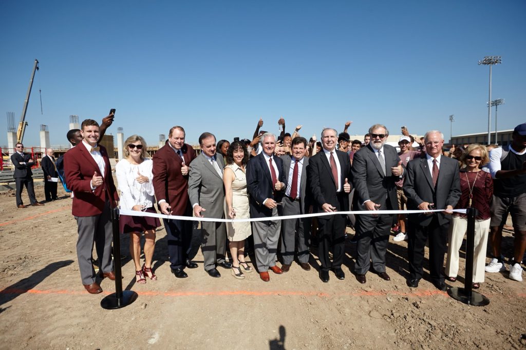 Texas A&M University and system administrators join coaches and donors for a ribbon cutting. 