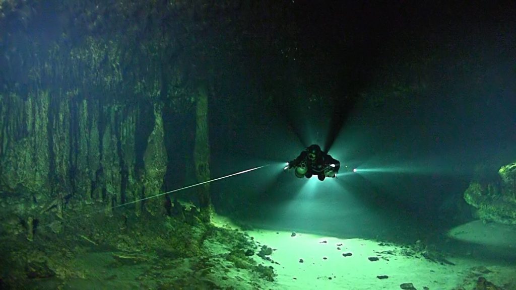 A member of the Texas A&M-led team uses a flashlight to navigate the underwater cave. 