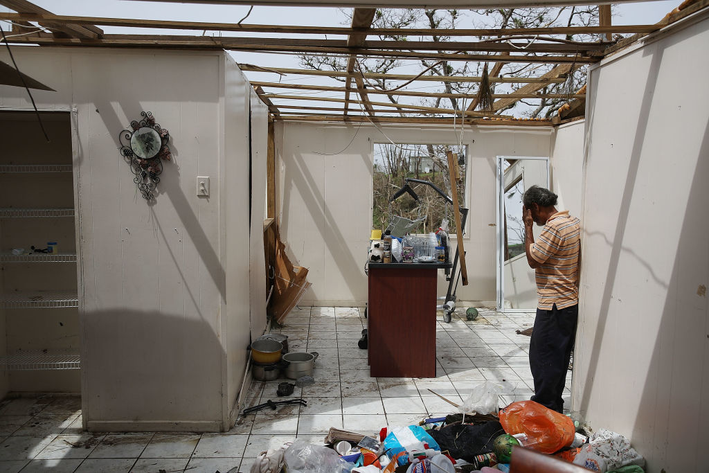 Ramon Torres stands in what is left of his sister-in-law's home that was destroyed when Hurricane Maria passed through on September 27, 2017 in Corozal, Puerto Rico. Puerto Rico experienced widespread, severe damage including most of the electrical, gas and water grids as well as agricultural destruction after Hurricane Maria, a category 4 hurricane, passed through. (Photo by Joe Raedle/Getty Images)