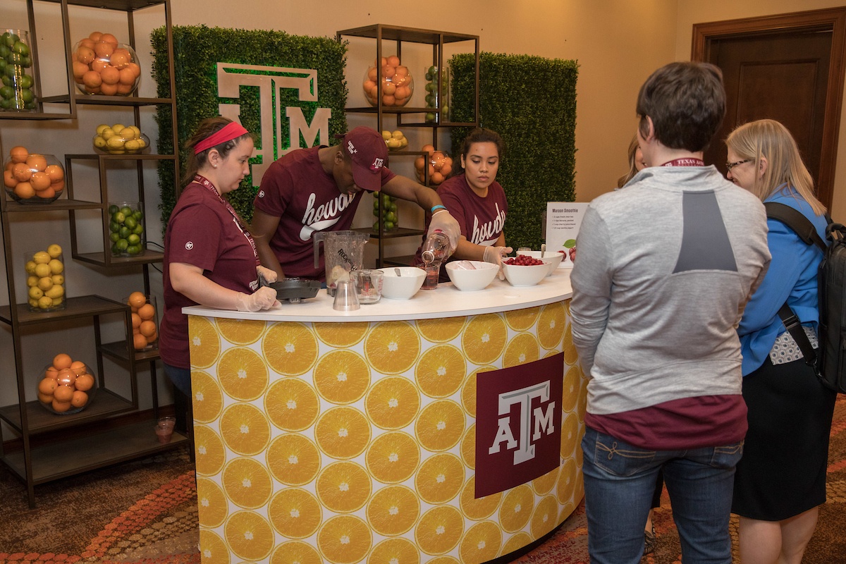 Student volunteers serve up special Aggie smoothies at the Saving Mornings smoothie bike station in the Discovery Lounge.