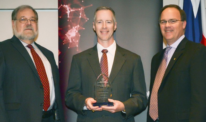 Associate Professor Mark E. Benden (center) of the School of Public Health at Texas A&M University accepts the 2018 Innovation Award from Texas A&M Vice President for Research Mark A. Barteau (left) and Brett Cornwell, executive director of Texas A&M Technology Commercialization.