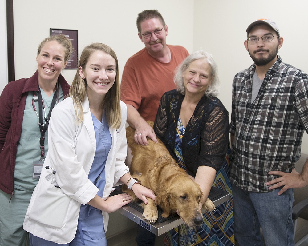 Tired from surgery, her hospital stay, and having 13 puppies, Bree Ann Rose was happy to return home with Mom, Angela Brenengen (right); Dad, Tim; and Brenengen’s nephew Norman Giles. With the family are Dr. Laurie Torkildsen and fourth-year veterinary student Ali Carriker.
