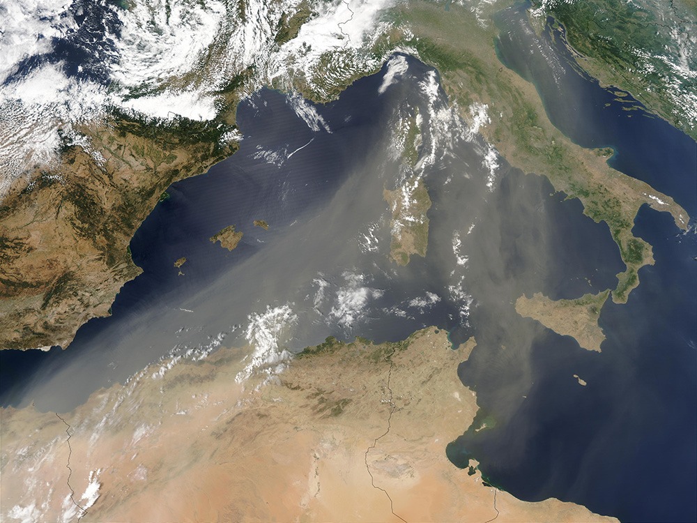 On July 16, 2003, the Moderate Resolution Imaging Spectroradiometer (MODIS) on the Aqua satellite captured this image of a river of Saharan dust streaming out over the Mediterranean Sea and northeastward to Italy. (NASA)