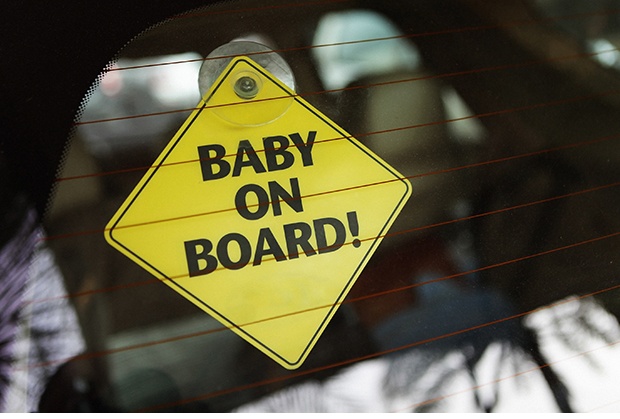 Yellow diamond shape sticky sign with the phrase baby on board written on the rear windsheild of a car.Similar Images..