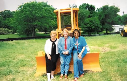 Dorothy McFerrin (left) and Becky Gates (center) stand on the plot that would expand the Becky Gates Children’s Center. (Texas A&M Student Affairs)
